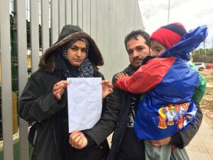 Los padres, que permanecen junto a uno de sus hijos, muestran el documento de la Fiscalía de Menores