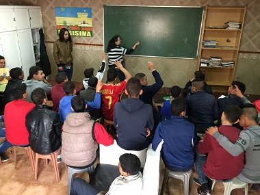 La profesora conduce la clase, mientras los alumnos realizan preguntas