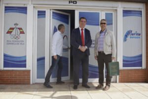 Antonio Miranda y Juan Manuel Sánchez posan ante la puerta de la nueva sede, junto a Manuel Busto, secretario general de la Federación Melillense