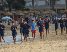 La plantilla realizando carrera continua sobre la arena de la Playa de San Lorenzo
