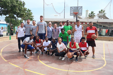 Foto de familia del Club Melilla Baloncesto con los internos del CETI