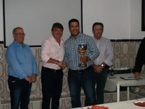 Faisal Azzoui recogiendo la copa de campeón de manos del máximo responsable de la Territorial, Víctor Fernández