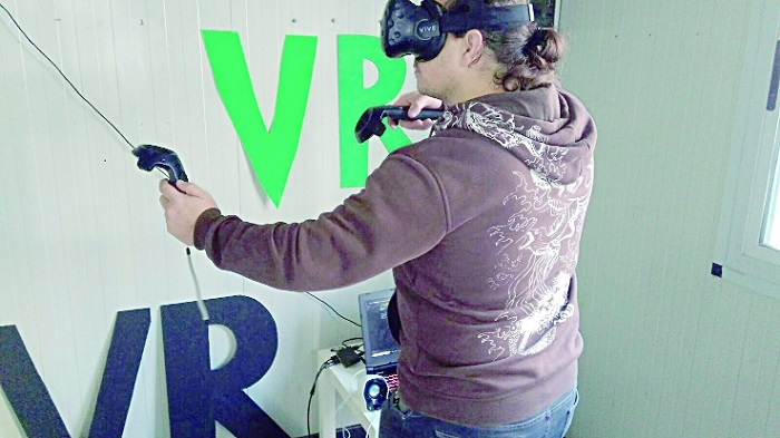 Una niña jugando con la realidad virtual a uno de los cuatros juegos programados donde se puede ser superhéroe, astronauta o viajar por el espacio