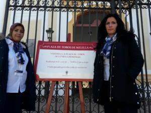 Dos azafatas muestran los horarios de las visitas