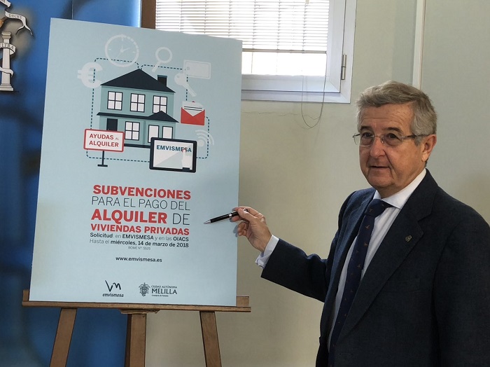 Imagen del consejero de Fomento, Javier González junto al cartel de las ayudas para el alquiler