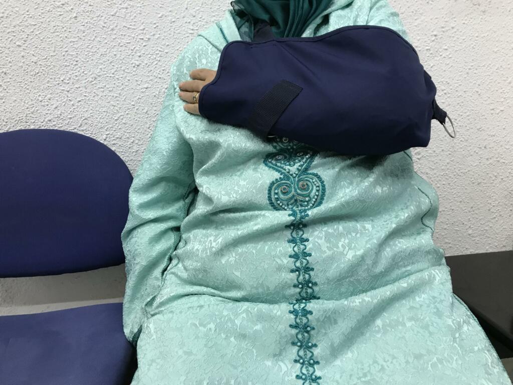 En la imagen, la mujer mostrando su brazo lesionado