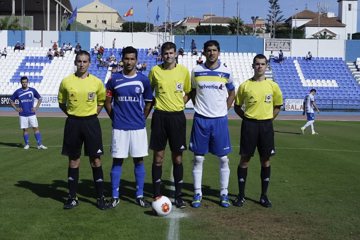 El trío arbitral y los dos capitanes del Melilla y el Écija, en el encuentro que el decano del Grupo IV ganó por 3-0