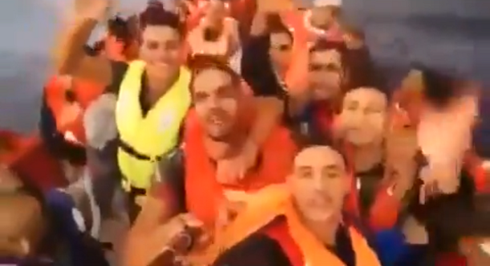 Los inmigrantes, grabando un vídeo en una patera con un móvil y un palo-selfie