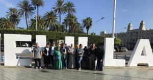 Alumnas, monitoras y la viceconsejera, junto al letrero de Melilla
