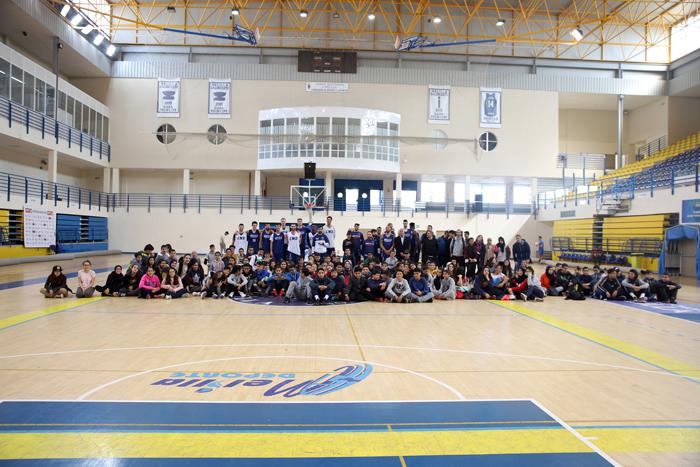 Foto de familia de los componentes del Club Melilla Baloncesto con los alumnos y los profesores del IES Rusadir