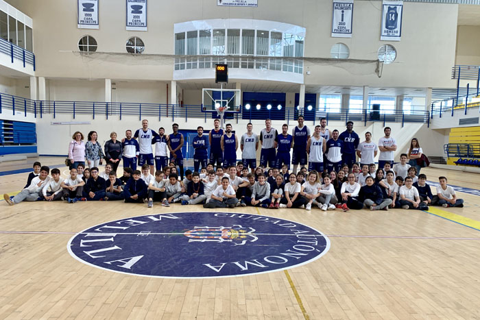 Foto de familia de los componentes del Club Melilla Baloncesto con los alumnos y los profesores del CEIP Reyes Católicos