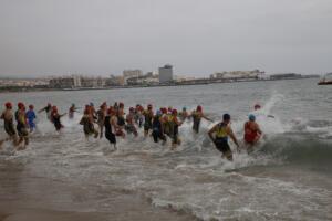 Los triatletas, entrando al agua para completar el segmento de la natación
