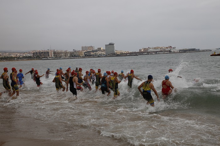 Los triatletas, entrando al agua para completar el segmento de la natación