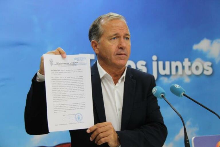 El secretario general del PP de Melilla, Miguel Marín, muestra el escrito del PP