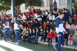 Los jugadores saludando a los chavales en su entrada al centro escolar