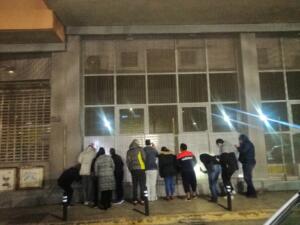 Algunas de las personas que acudieron anoche al INEM a pesar del frío, la poca luz y unos folios a más de un metro de distancia tras unos barrotes de hierro