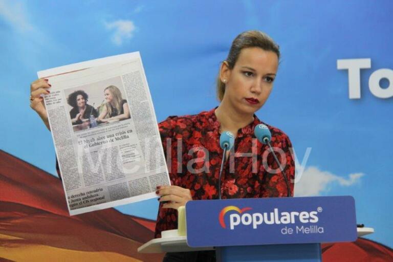 La diputada local del PP Isabel Moreno, muestra un recorte de prensa de El País