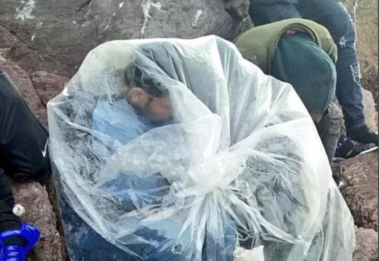 Este migrante se cubre con plástico para combatir las bajas temperaturas