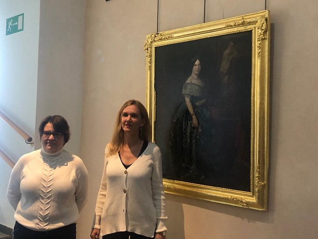La restauradora Vanesa Martínez y la consejera Elena Fernández con el cuadro de Isabel II