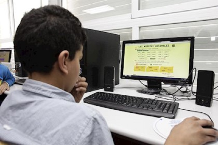 Un alumno con un ordenador en clase