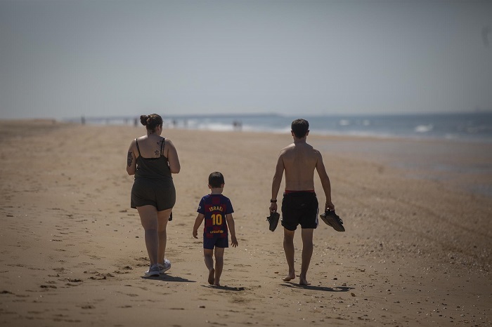 Una familia paseando por la playa