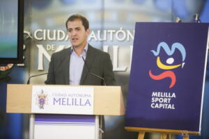 Rachid Bussian posando con el nuevo logo de la Consejería de Deporte