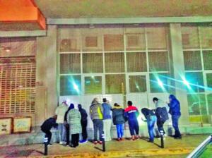 Foto de archivo de ciudadanos melillenses consultando las listas de seleccionados de los planes de empleo