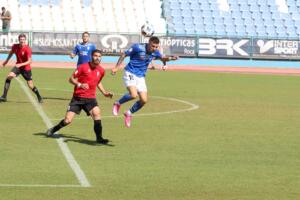 Mawi, futbolista de la U.D. Melilla, se anticipa a un jugador rival en el juego aéreo