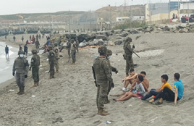 Imagen de militares ayudando a las FyCSE en la playa del Tarajal tras la entrada de miles de migrantes