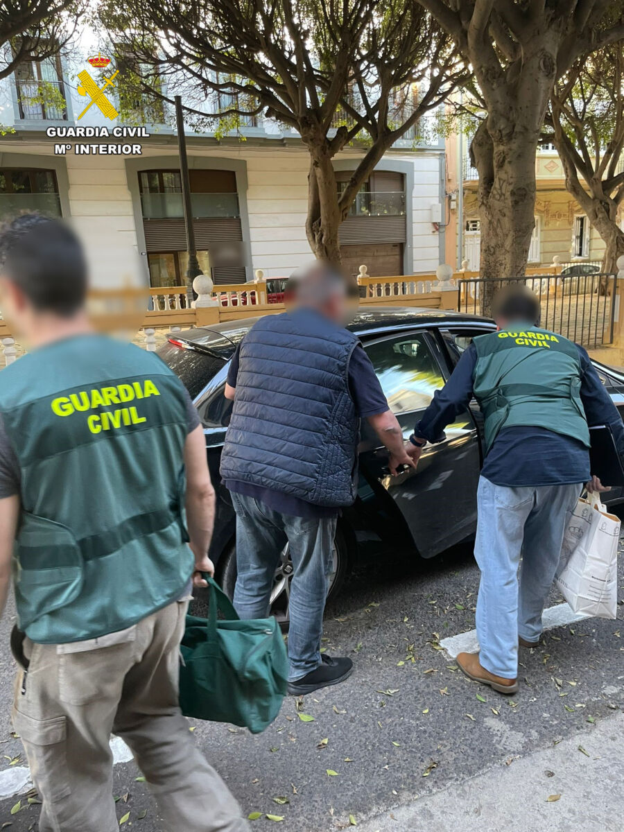 Dos agentes conducen al detenido por presunta estafa en Melilla
