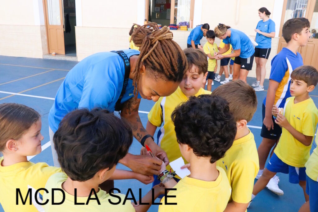 Jugadora firmando autógrafos a niños en el colegio La Salle