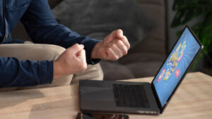 Persona emocionada jugando en un ordenador portátil con juegos de azar