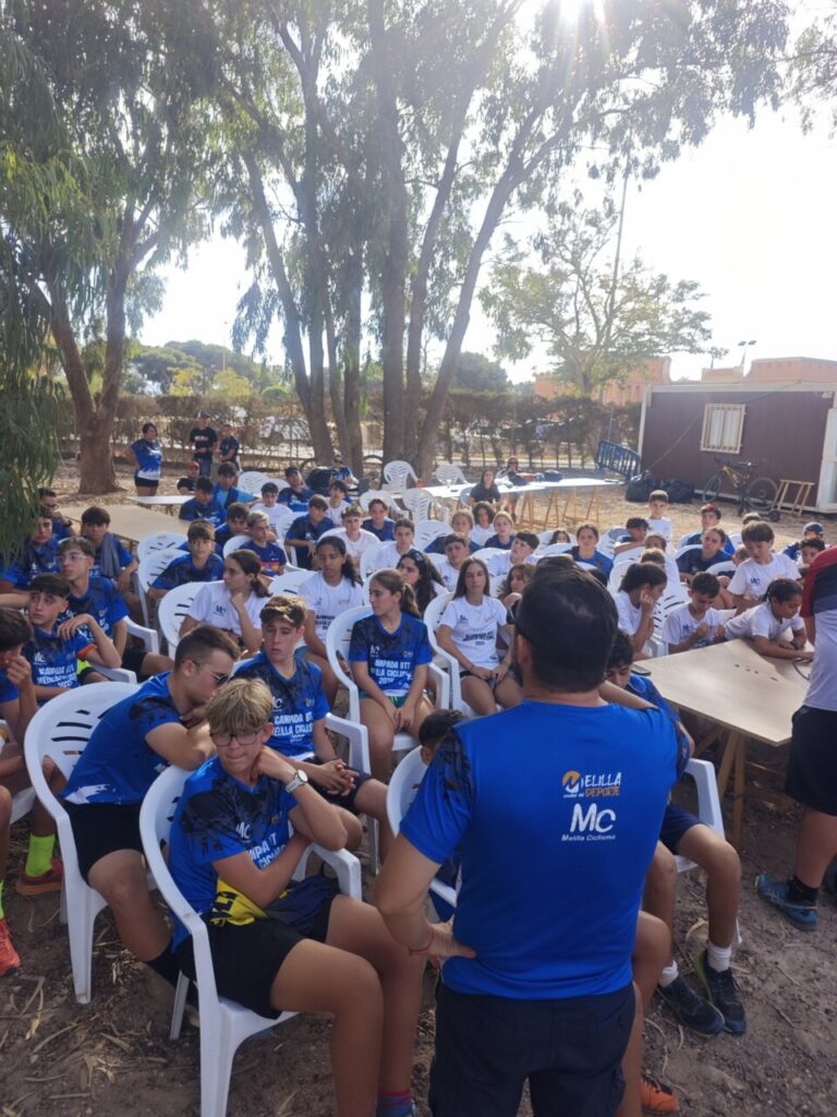 Grupo de jóvenes en la II Acampada BTT Melilla sentados en sillas