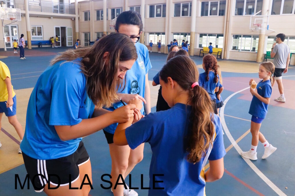 Jugadoras del equipo firmando autógrafos a niños en el colegio La Salle