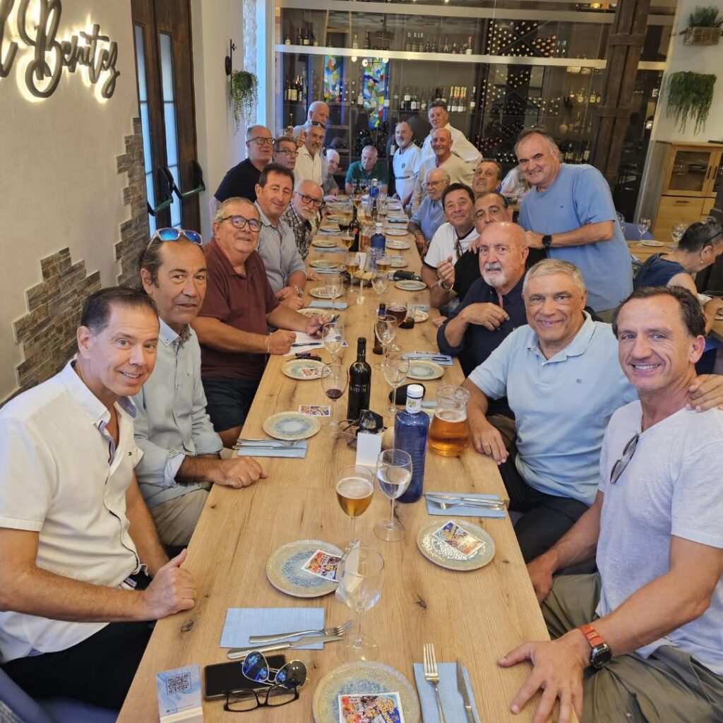 Grupo de amigos del balonmano reunidos en una mesa celebrando