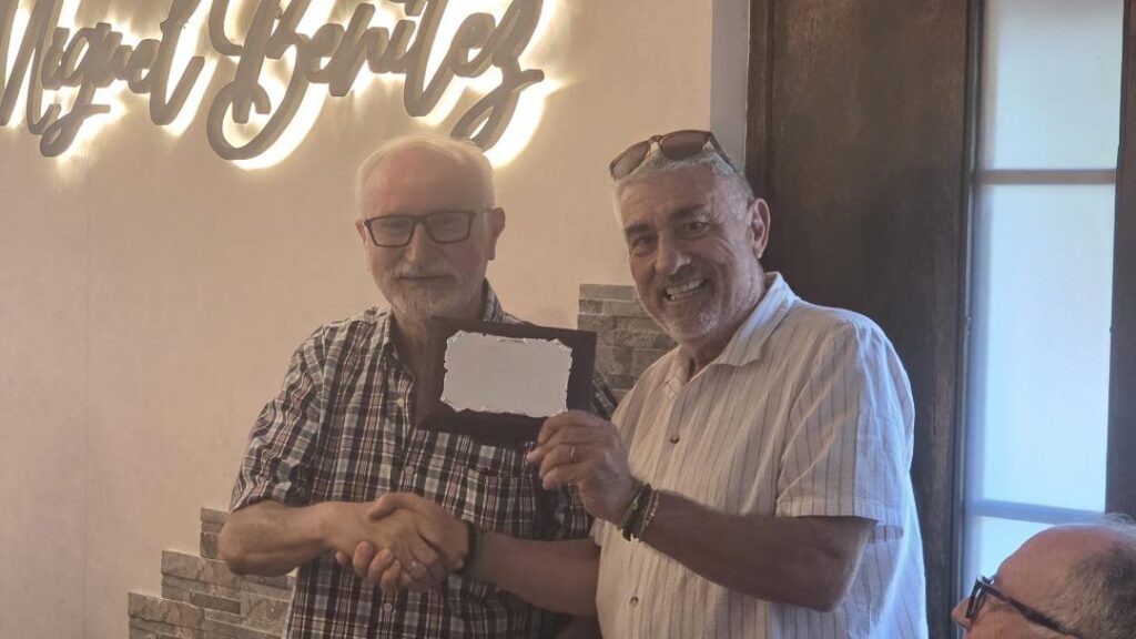 Dos hombres se dan la mano en un evento de balonmano.