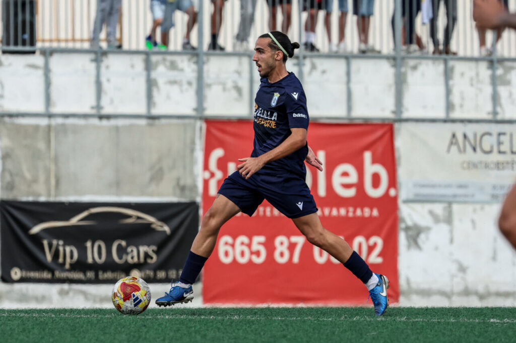 Jugador de la U.D. Melilla en acción durante un partido de fútbol.