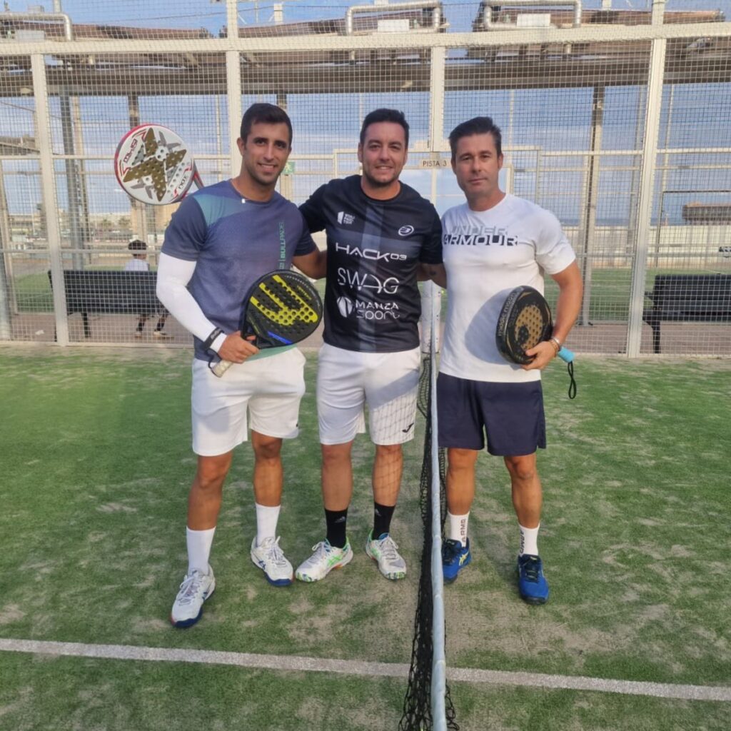 Tres jugadores de pádel posando en la cancha durante el torneo solidario.