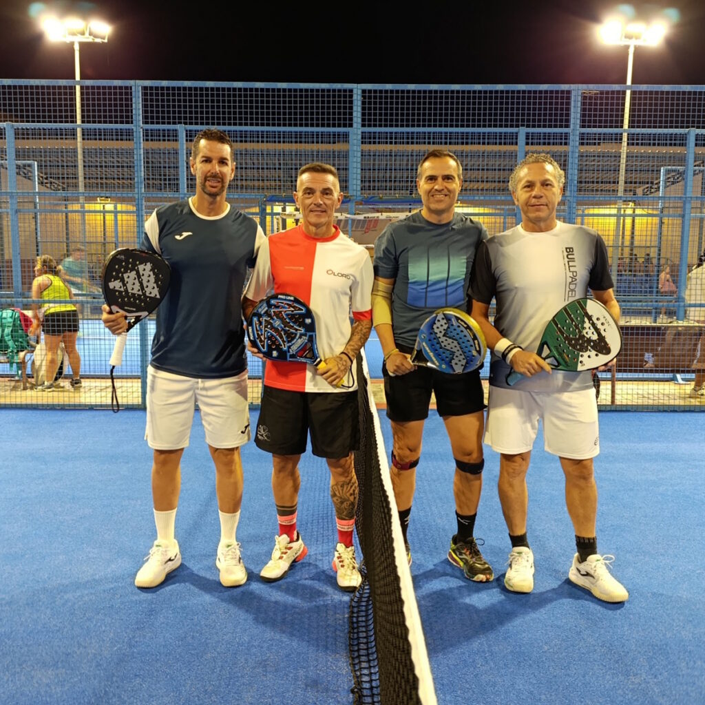 Cuatro jugadores de pádel posando en la cancha tras el torneo de veteranos.