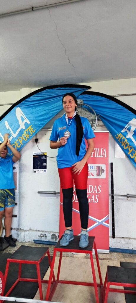 Joven levantadora de pesas con medalla en competición