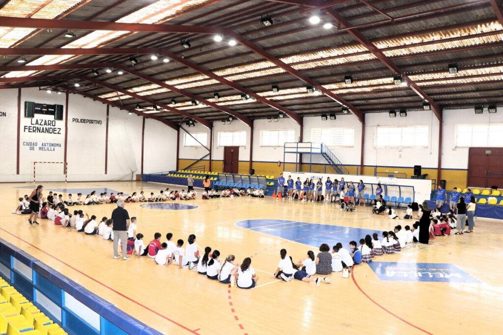 Jugadores y alumnos en el Pabellón Lázaro Fernández durante una actividad deportiva.