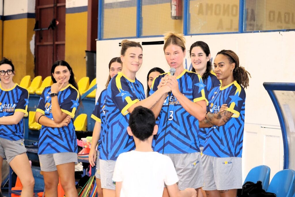 Jugadoras del MCD La Salle interactuando con alumnos en el pabellón.