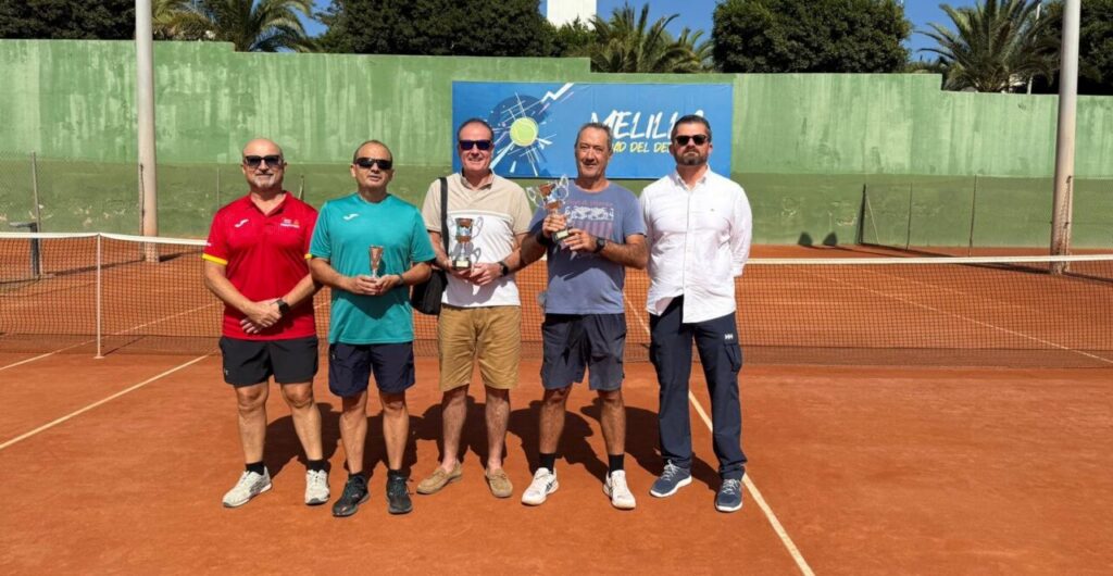 Participantes del torneo de tenis veteranos en Melilla mostrando trofeos.