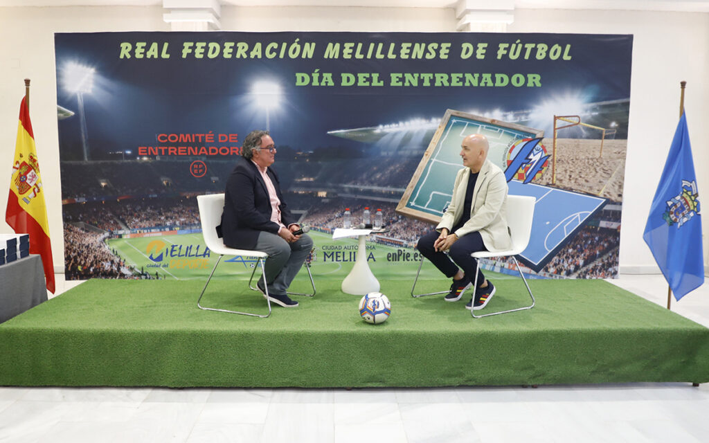 Dos hombres conversando en el Día del Entrenador de la RFMF