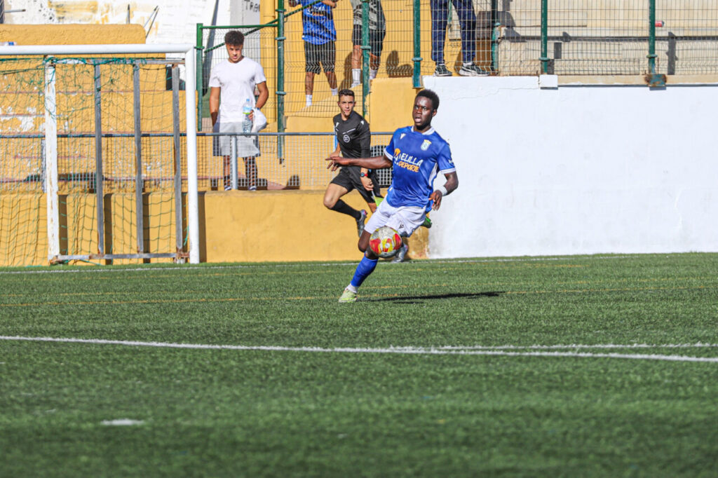 Jugador de la U.D. Melilla B corriendo con el balón durante un partido