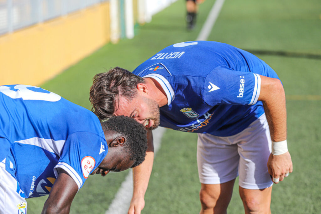 Jugadores de la U.D. Melilla B celebrando una victoria en el campo.