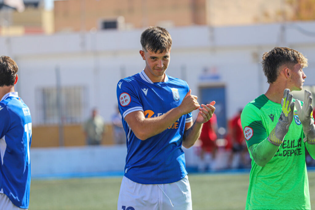 Jugadores de la U.D. Melilla B celebrando tras una victoria en el campo.