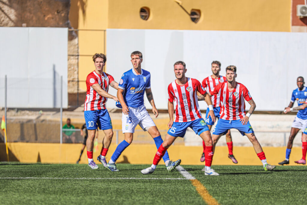 Jugadores de U.D. Melilla B y Atlético Porcuna en el campo