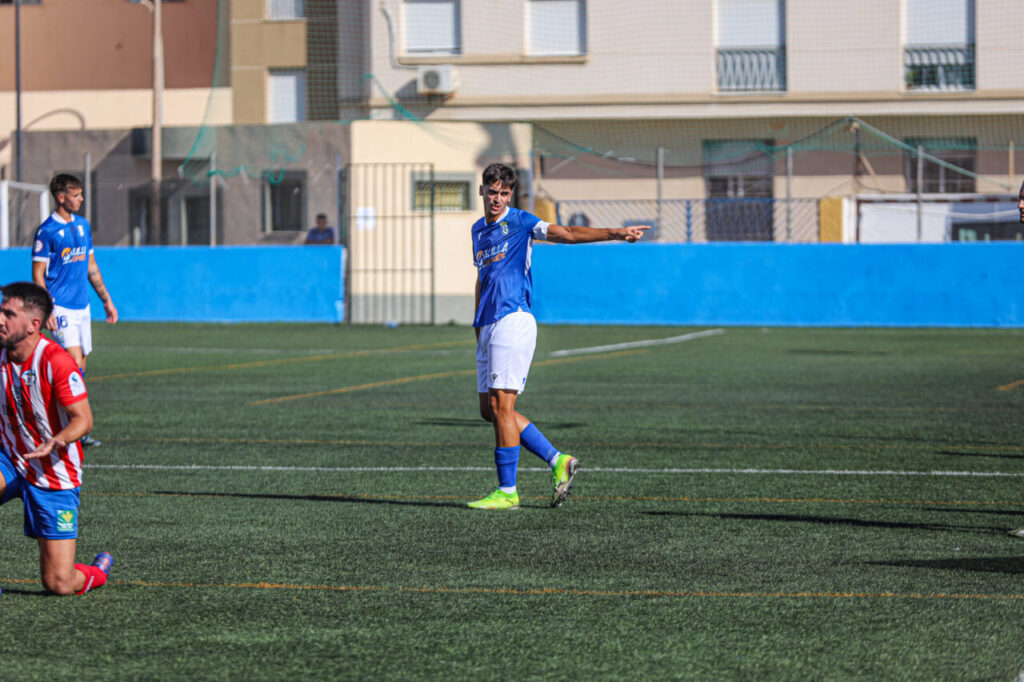 Jugador de la U.D. Melilla B señalando durante un partido de fútbol