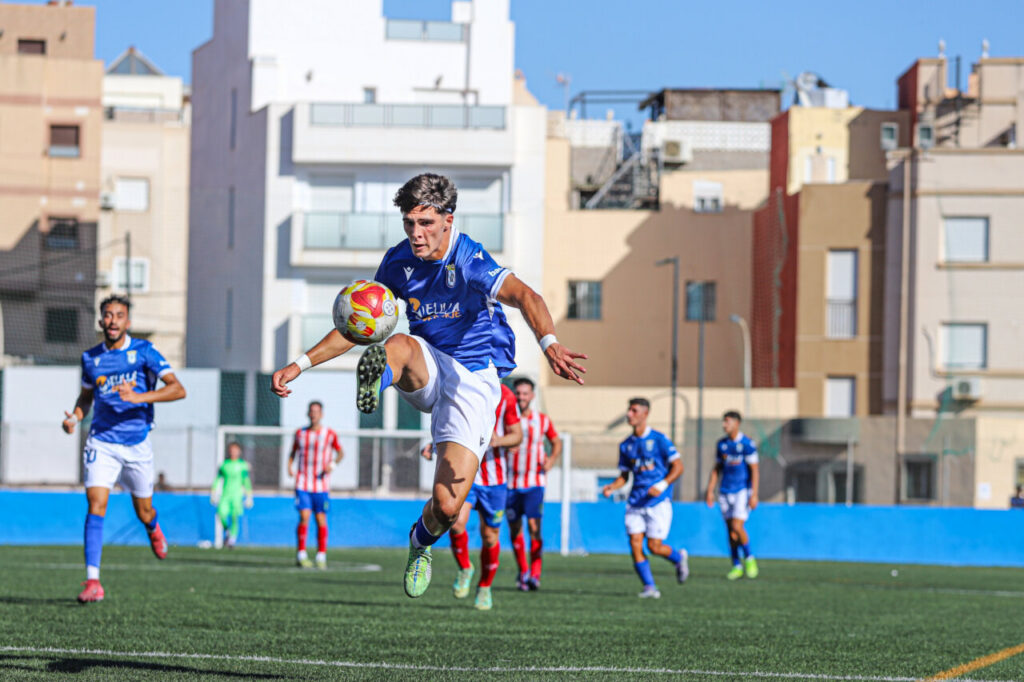 Jugador de la U.D. Melilla B controla el balón durante el partido